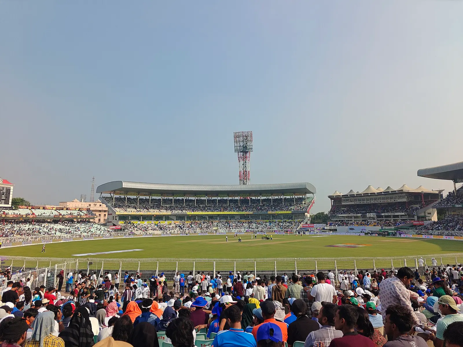 Crowd and floodlight towers at Eden Gardens cricket ground in Kolkata
