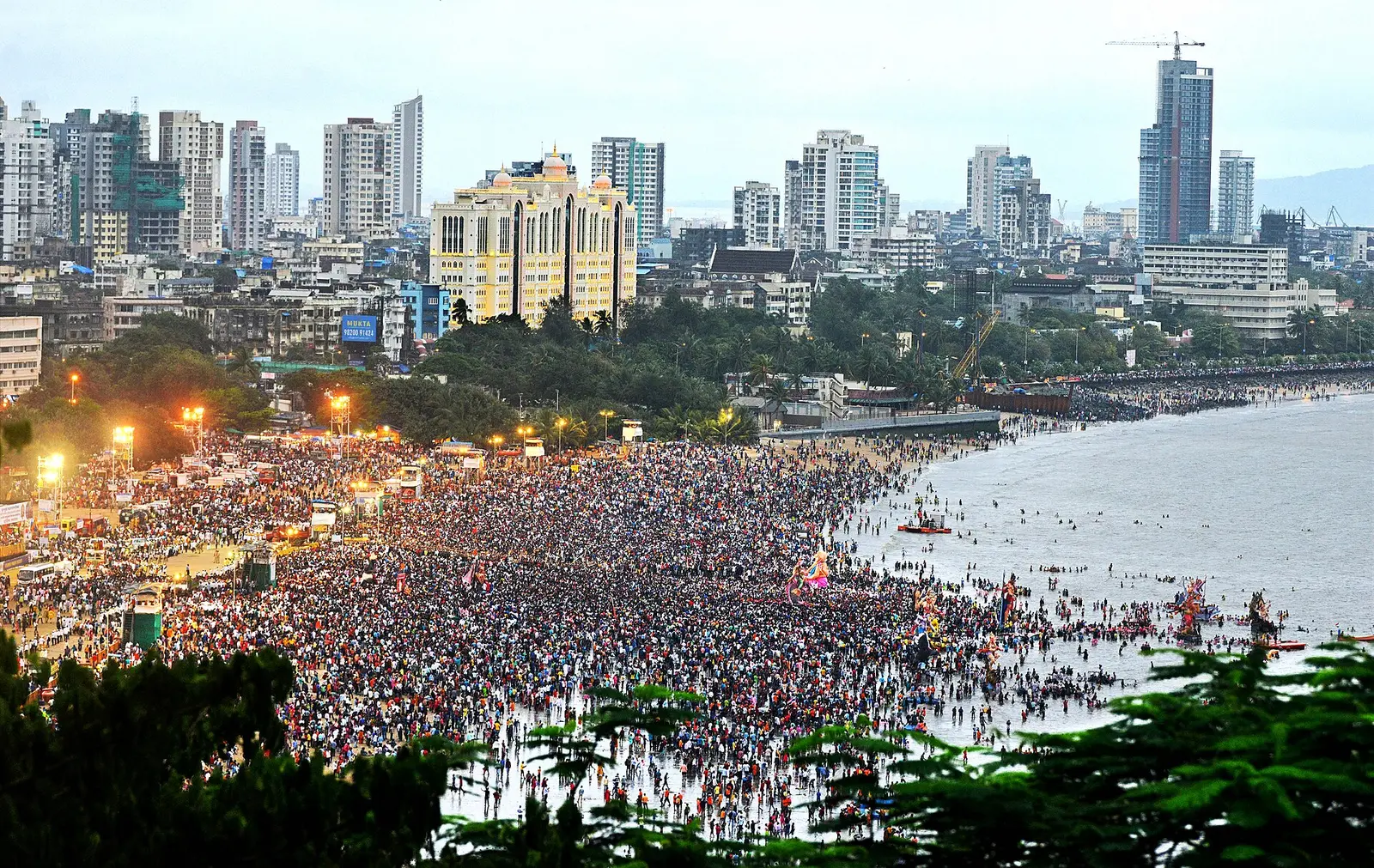 Huge crowd on the shore at Mumbai during Ganesh immersion with the city skyline behind