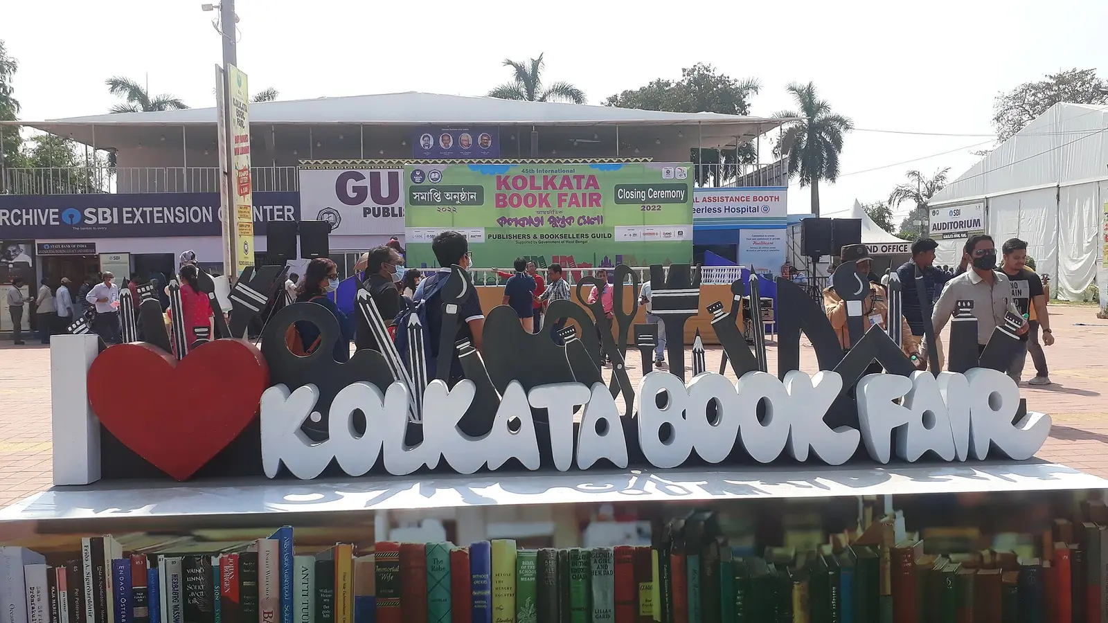 Visitors at the Kolkata Book Fair sign among publishers' stalls