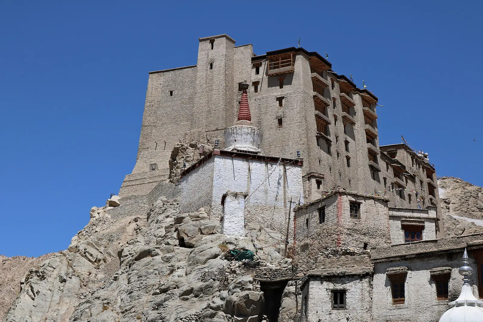 Leh Palace rising over the old town of Leh, Ladakh, under a blue sky