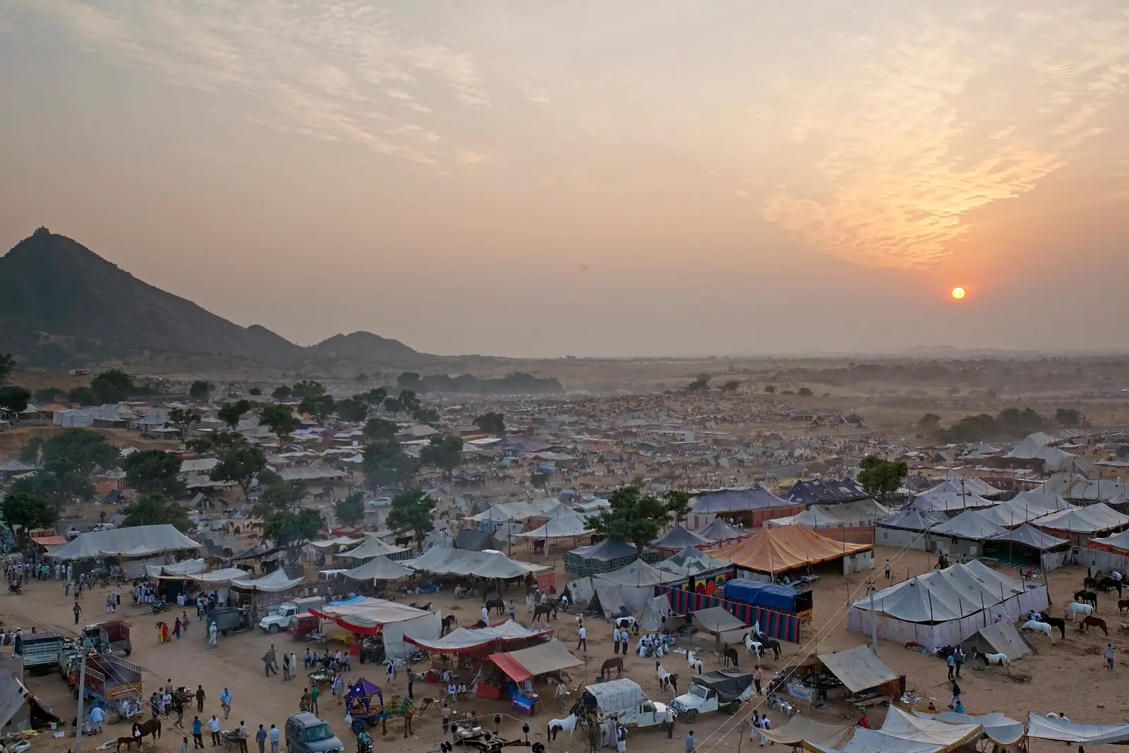 Tents and stalls of the Pushkar mela grounds under a setting sun
