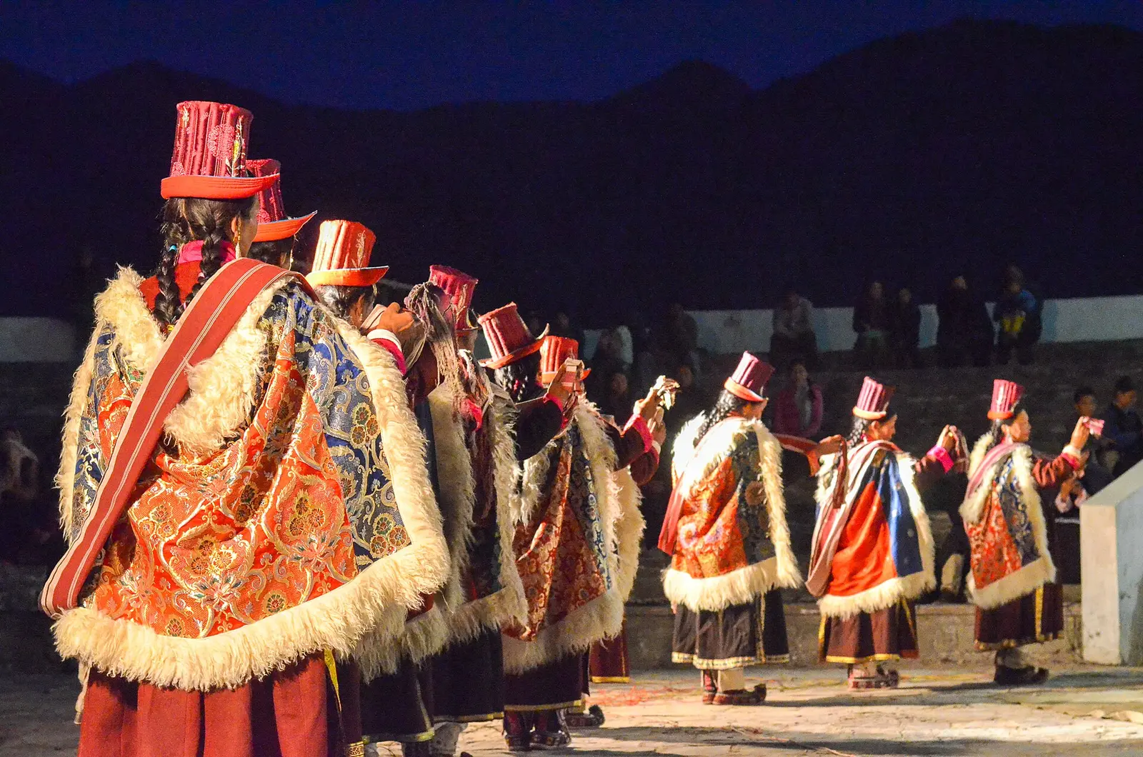 Dancers in Ladakhi costume and tall hats at an evening Sindhu Darshan festival performance