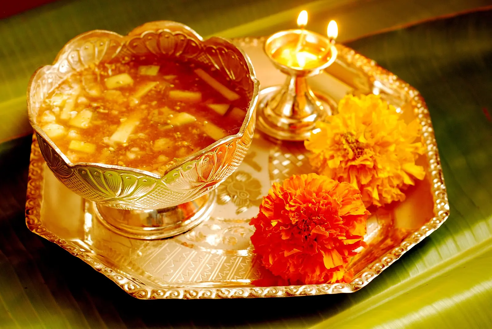 Ugadi pachadi in a silver bowl on a puja tray with a lamp and marigolds